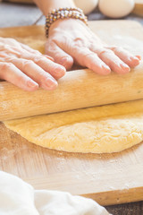 Woman kneading a dough whith rolling pin