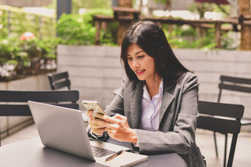 Business Concept.Young Asian businesswoman is working happily.Young businesswoman working in a cafe.Young businesswoman is relaxation in a coffee shop.