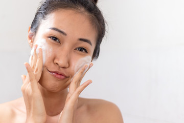 Asian women are using facial foam.