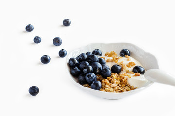 Healthy  breakfast granola with blueberries and yogurt in a bowl isolated