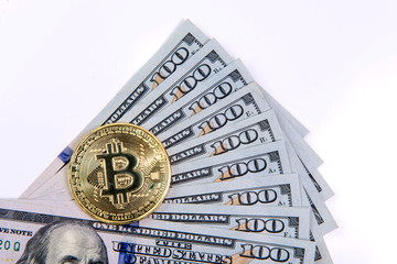 Cryptocurrency physical golden bitcoin coin on us dollars close up