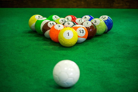 Shot of foot pool balls standing on green table. Foot Pool is the hybrid combination of pool and soccer. Big billiard balls. 
