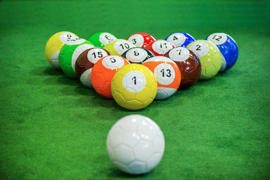 Shot of foot pool balls standing on green table. Foot Pool is the hybrid combination of pool and soccer. Big billiard balls. 