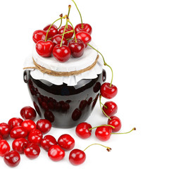 Cherries and jar of jam isolated on white.
