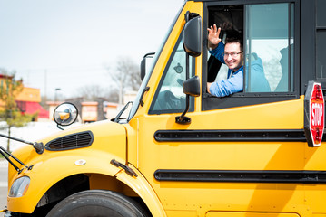 School bus driver waving out window - 201099411