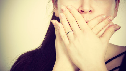 Woman covering her mouth with hand