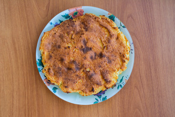 Casserole on a plate on the wooden table. Homemade
