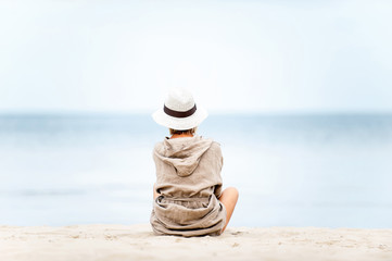 Young beautiful woman in hat contemplating Sea