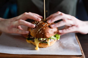 Woman's hands with hot burger. Fast food concept. Close up view.