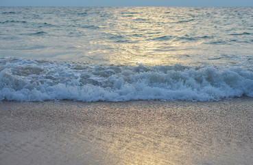 Sea water and waves hit the beach.