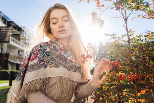 beautiful girl blonde walks on a spring sdu, enjoys nature, plants and the sun