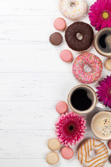 Coffee cups, donuts and gerbera flowers