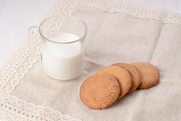 Homemade ginger cookies with a glass of milk on a wooden light b
