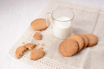 Homemade ginger cookies with a glass of milk on a wooden light b