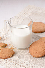 Homemade ginger cookies with a glass of milk on a wooden light b