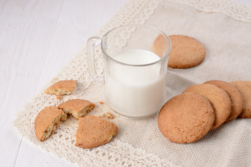 Homemade ginger cookies with a glass of milk on a wooden light b
