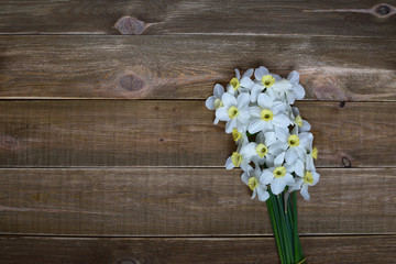 Fresh bouquet of narcissus on a wooden table. Spring and celebration concept background. 