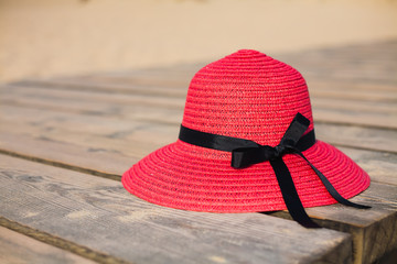 Red hat on wooden deck on the beach.