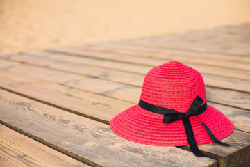 Red hat on wooden deck on the beach.
