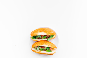 Homemade hot dogs with grilled sausages and greenery on white background top view copy space