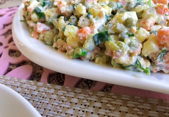 Russian traditional salad Olivier with vegetables and meat. Winter salad