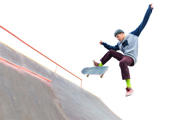 The teenager skateboarder in the cap does a trick with a jump on the ramp in the skatepark. Isolated skater and ramp on white background