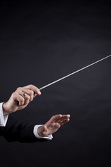 Conductor conducting an orchestra isolated on black background