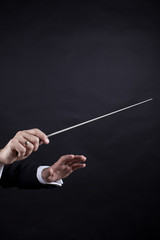 Conductor conducting an orchestra isolated on black background