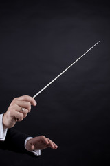 Conductor conducting an orchestra isolated on black background