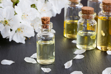 Bottles of essential oil with white blossoms
