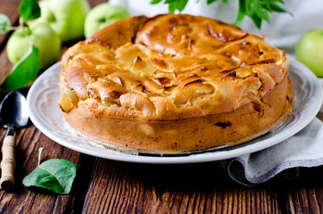 Apple cake on the plate on a wooden table