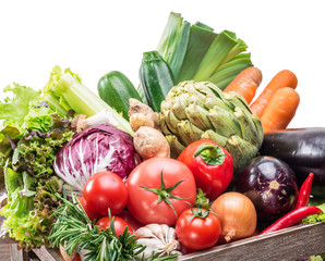 Fresh multi-colored vegetables in wooden crate.