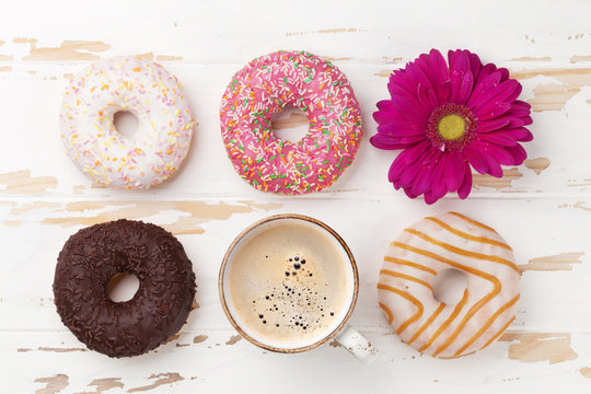 Coffee cup, donuts and gerbera flower