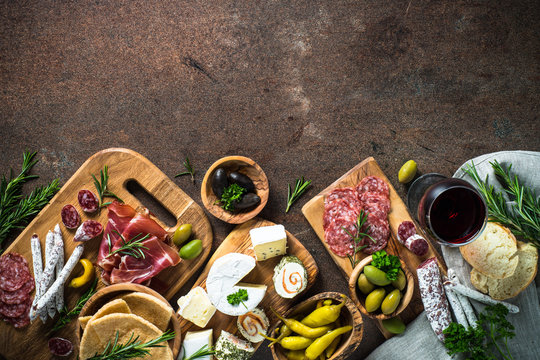 Antipasto delicatessen - meat, cheese, olives and wine on stone 