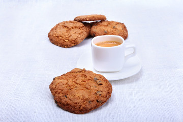 Classic espresso in white cup with cake and chocolate on white background.