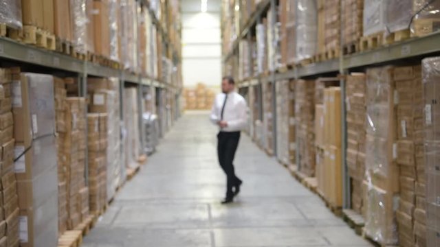 erfolgreicher Gesch&auml;ftsmann einer Logistikfirma im Warenlager // successful businessman of a logistics company in a warehouse