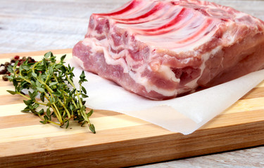 Raw pork chops, spices and rosemary on cutting board. Ready for cooking.