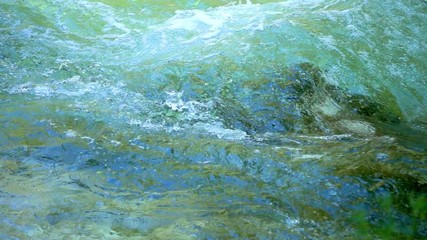 SLOW MOTION: flowing water over stones in mountain river