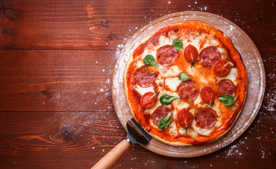 classic Italian pizza on a wooden tray, served in a small authentic Italian restaurant