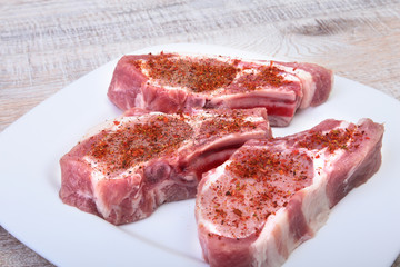 Raw pork chops, spices on cutting board. Ready for cooking.