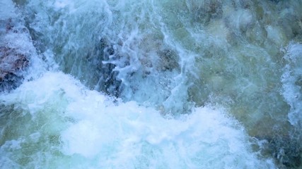 SLOW MOTION: flowing water over stones in mountain river