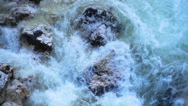 SLOW MOTION: flowing water over stones in mountain river