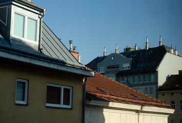 Fototapeta na wymiar Sunny roof with attic, chimneys and TV antennas