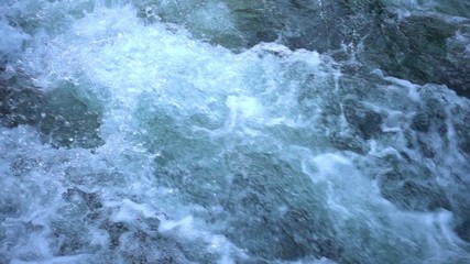 SLOW MOTION: flowing water over stones in mountain river
