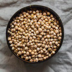 Sprouted chickpea in wooden bowl on rustic linen textile. Bean sprouts raw. Source of protein for vegan healthy diet.