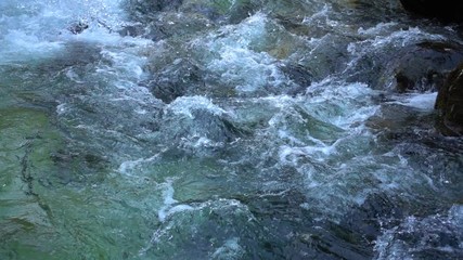 SLOW MOTION: flowing water over stones in mountain river