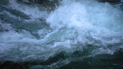 SLOW MOTION: flowing water over stones in mountain river