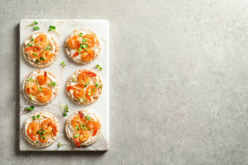 Delicious small sandwiches with shrimps on marble board