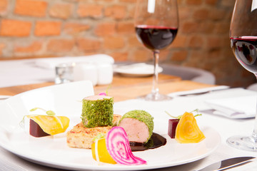 Roast pork tenderloin with crispy potato bread, marinated beetroots and green pepper sauce served in a restaurant