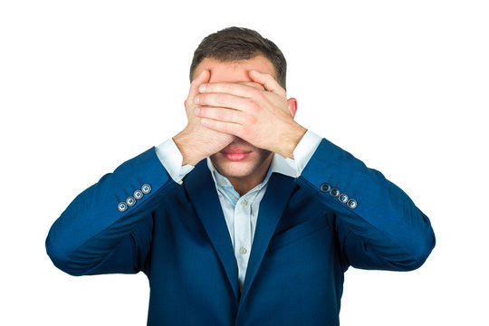 Young Man In Suit Closes His Eyes With His Hands. See No Evil.